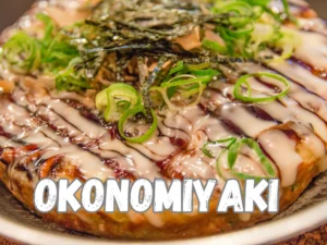 Um Okonomiyaki japonês, uma panqueca japonesa tradicional, adornada com uma variedade de ingredientes frescos, como repolho picado, camarão, polvo ou bacon, coberta com molho okonomiyaki, maionese japonesa, flocos de bonito seco e flocos de nori.