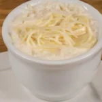 Arroz Piamontese cremoso com cogumelos e queijo parmesão, servido em um prato elegante.