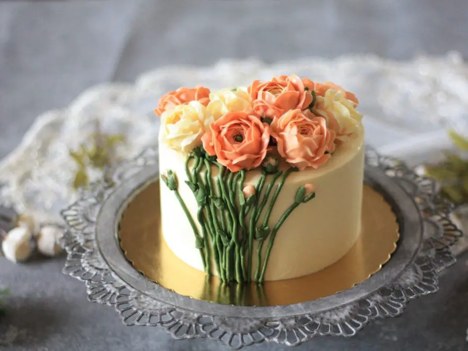 Mini bolo coberto com buttercream cremoso, decorado com flores delicadas.