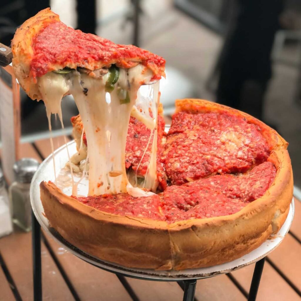 Chicago Deep Dish Pizza com borda alta e recheio generoso, parecendo uma torta salgada.