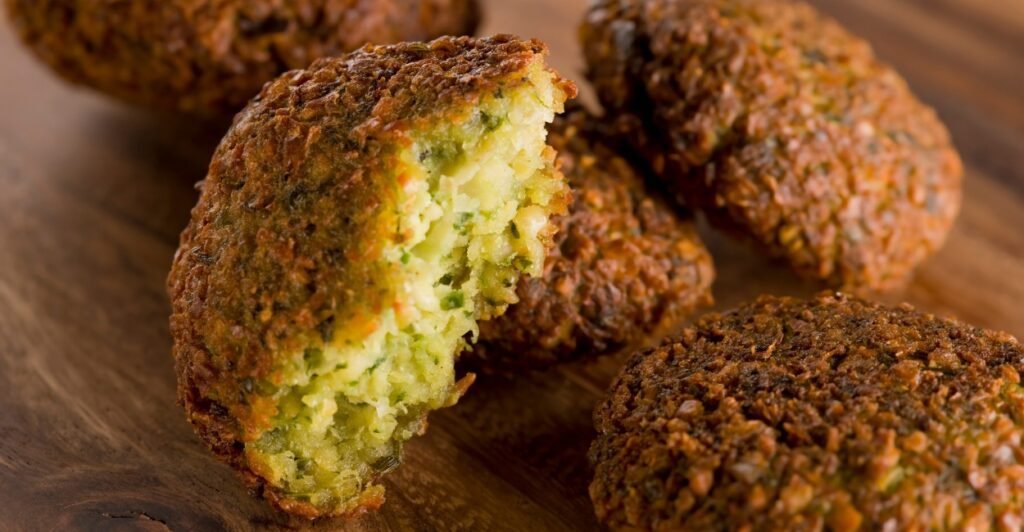 Falafel crocante servido com molho de tahine e salada, prato típico da culinária árabe.