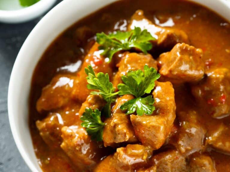 Goulash servido em uma panela, com carne suculenta, vegetais coloridos e especiarias.