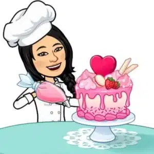 Jo Gourmand com uma manga de confeitar fazendo decoração com glace em bolo de festa.