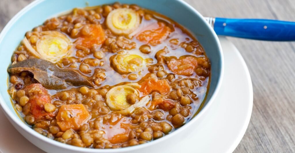 Tigela de lentejas estofadas, prato quente de lentilhas cozidas com legumes e temperos.