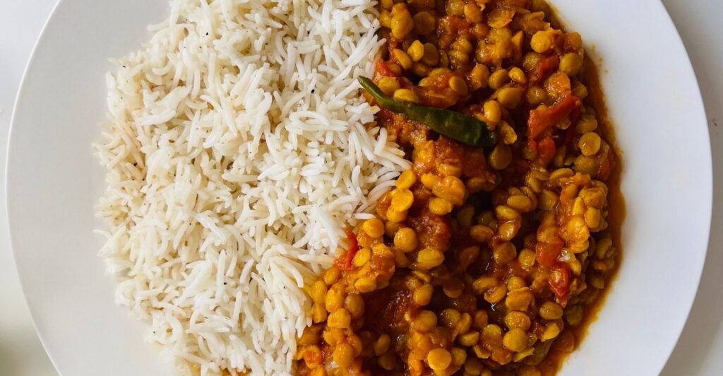 Prato de lentilha brasileira cozida com legumes e temperos, servido com arroz branco.