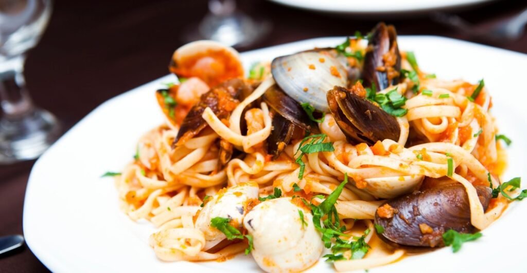 Prato de linguine com frutos do mar, incluindo camarões, mexilhões e mariscos, com molho leve.
