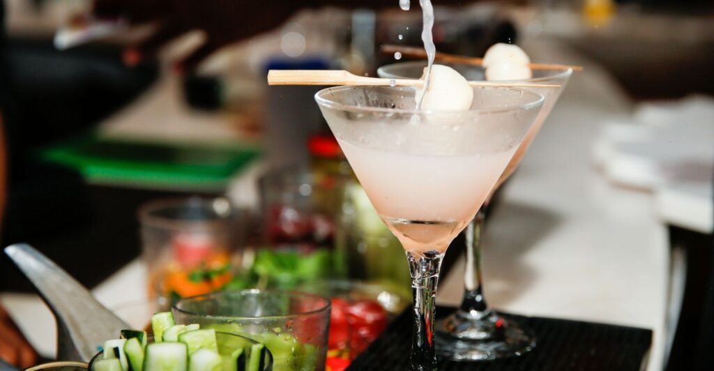 Copo de Lychee Martini decorado com uma fruta lichia fresca na borda.