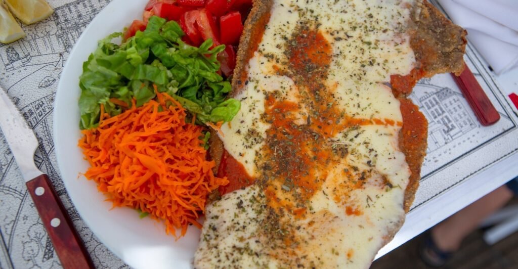Milanesa a la napolitana com molho de tomate, presunto e queijo, prato típico da culinária argentina.