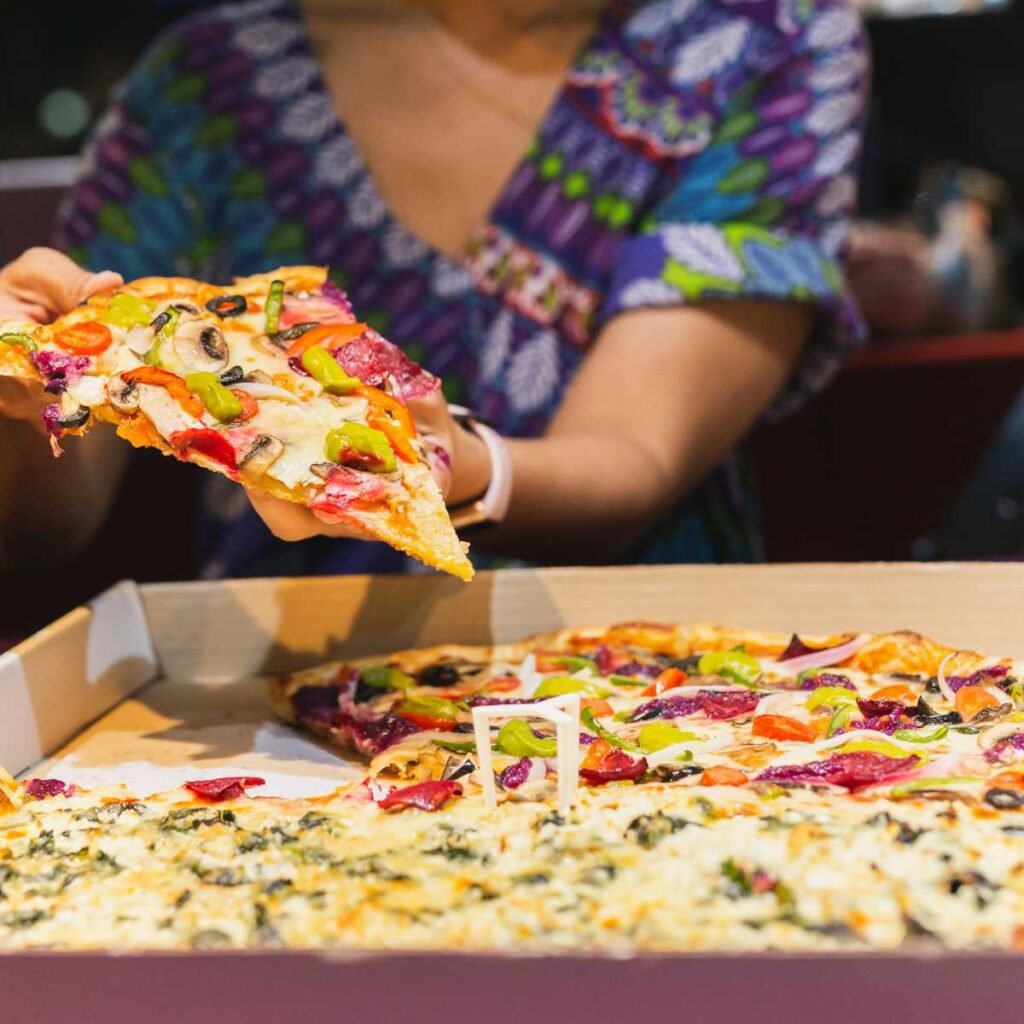 New York-Style Pizza, fina e crocante, cortada em fatias grandes e dobráveis.