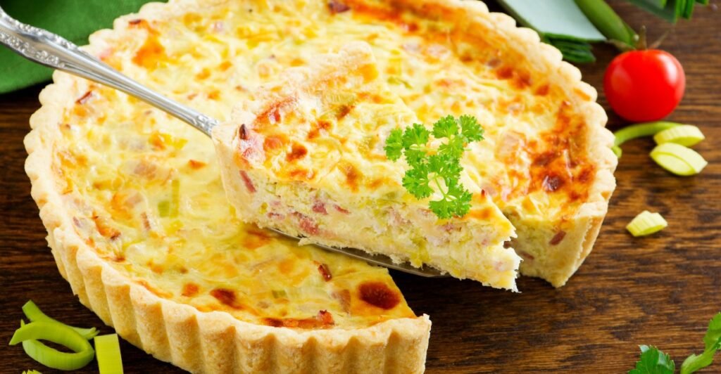 Quiche Lorraine dourada, recheada com creme, ovos, bacon e queijo, prato típico da culinária francesa.