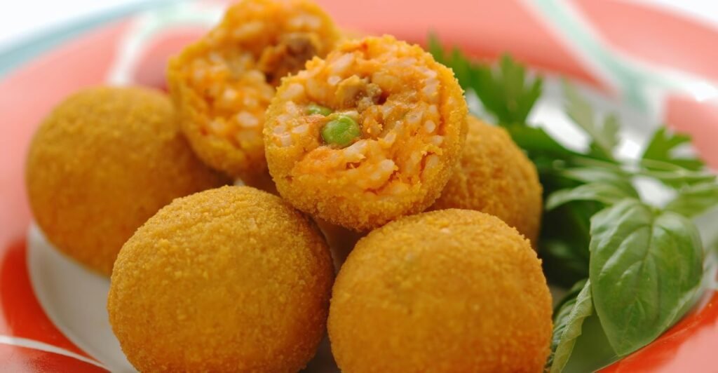 Prato de arancini: Bolinhos de arroz dourados e crocantes, servidos com uma deliciosa molho marinara. Uma explosão de sabores italianos em cada mordida!