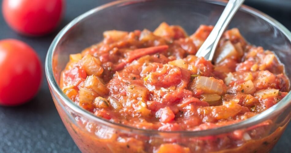 molho arrabbiata picante, decorado com folhas de manjericão fresco e queijo parmesão ralado.
