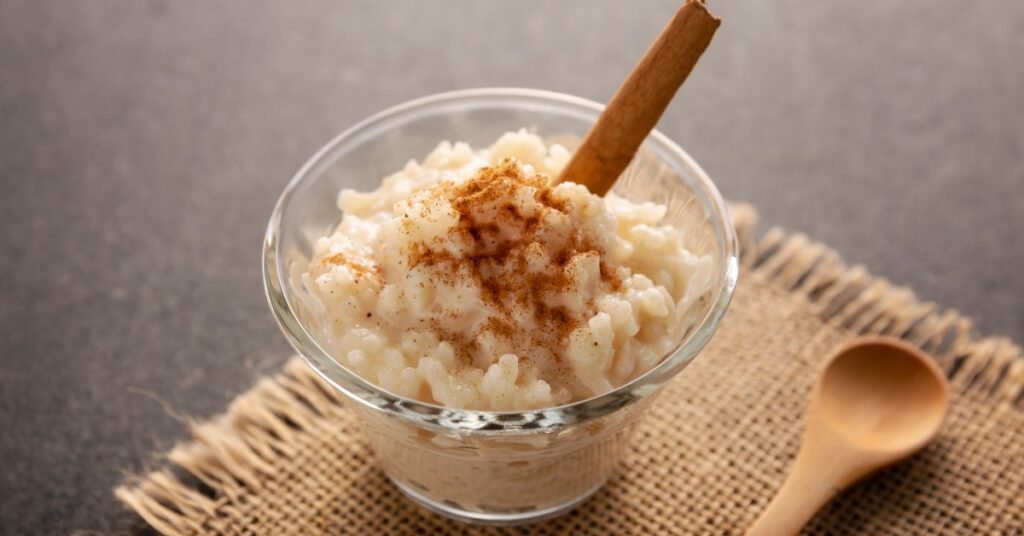 Arroz doce cremoso em tigela branca com canela polvilhada por cima,