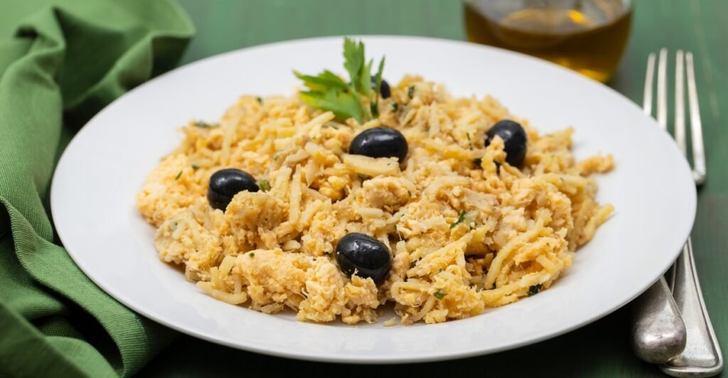 Bacalhau à Brás servido em prato tradicional com batata palha e ovos mexidos, típico da culinária portuguesa.