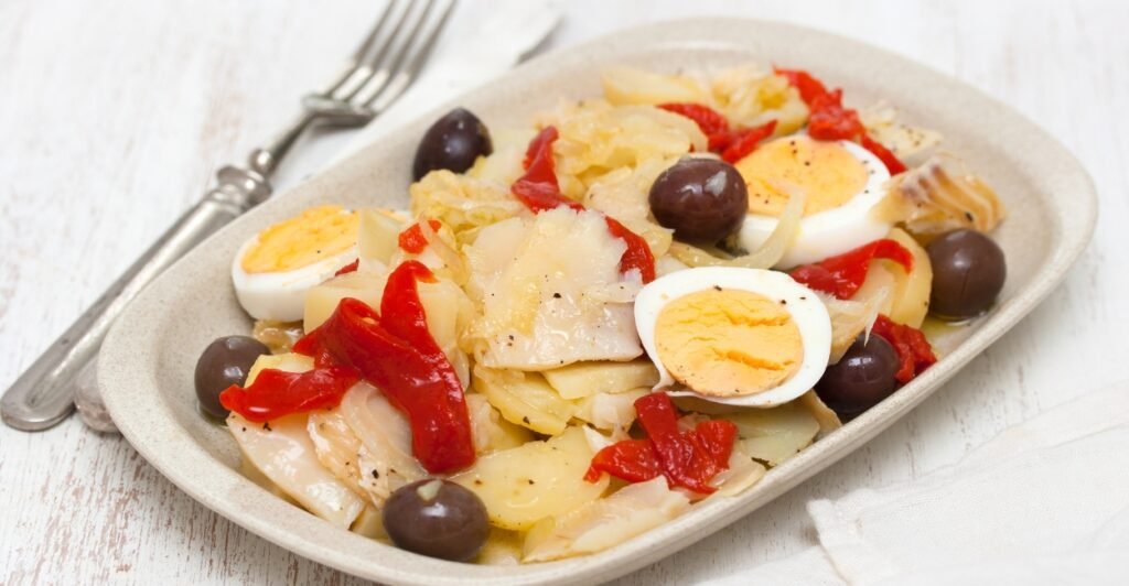 Bacalhau à Gomes de Sá com ovos cozidos, azeitonas pretas e batatas, prato clássico da culinária portuguesa.