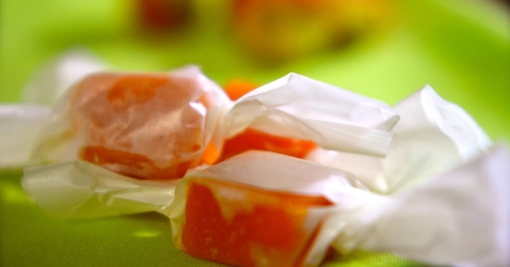 Balas puxa-puxa coloridas e brilhantes, esticadas à mão, típicas da comida de festa junina doce.