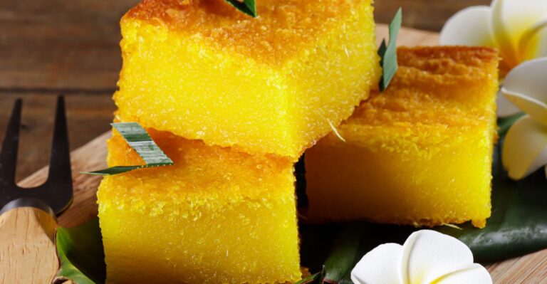 Bolo Souza Leão tradicional com textura cremosa, dourado e servido em fatia sobre prato de porcelana branca.