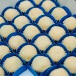 brigadeiro gourmet de leite ninho coberto com açúcar e servido em forminhas azuis.