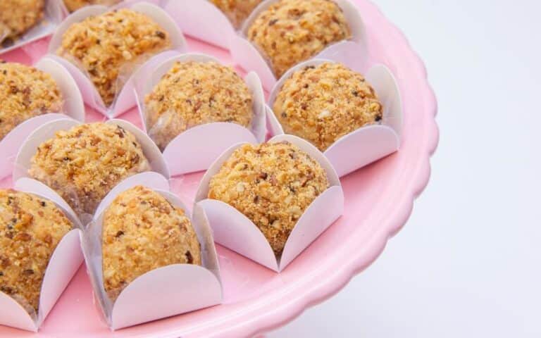 Brigadeiro gourmet de paçoca coberto com farofa de amendoim e servido em forminha decorativa.