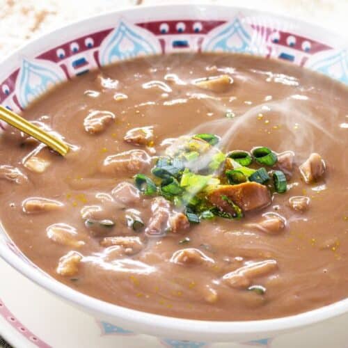 O caldo de feijão é uma receita clássica da culinária brasileira, apreciada em todas as regiões do país. Leve, nutritivo e cheio de sabor, esse prato combina feijão cozido, temperos aromáticos e, às vezes, carnes ou linguiça, resultando em uma refeição reconfortante, perfeita para dias frios ou para aquele momento em que se busca uma comida caseira e acolhedora. História do Caldo de Feijão O feijão é um dos alimentos mais tradicionais do Brasil desde a colonização, sendo base da alimentação diária das famílias. O caldo de feijão surgiu como uma maneira de aproveitar o feijão cozido, transformando-o em uma sopa nutritiva e saborosa. Ao longo do tempo, diferentes regiões do país adaptaram o caldo: No Sudeste, é comum adicionar linguiça ou bacon. No Nordeste, pode incluir temperos como coentro e pimenta-de-cheiro. No Sul, às vezes recebe carnes defumadas ou paio. Esse prato é símbolo da cozinha afetiva brasileira, trazendo lembranças de refeições familiares e momentos de conforto à mesa. Características e Sabores do Caldo de Feijão Sabor intenso e reconfortante, que destaca o feijão e os temperos. Textura cremosa, quando batido parcialmente ou cozido até desmanchar. Versatilidade: pode ser servido puro, com carnes ou até com legumes. Aroma acolhedor, graças à combinação de alho, cebola, folhas de louro e temperos regionais. Dicas para um Caldo de Feijão Perfeito Use feijão de boa qualidade, preferencialmente deixado de molho por algumas horas. Cozinhe com temperos aromáticos, como alho, cebola e louro, para intensificar o sabor. Bata parcialmente o feijão cozido para obter uma textura cremosa, se desejar. Finalize com carnes defumadas ou linguiça para uma versão mais robusta. Sirva quente, acompanhado de arroz branco, torresmo ou pão caseiro. Curiosidades sobre o Caldo de Feijão É considerado um prato de conforto e muito presente em mesas familiares no Brasil. Em algumas regiões, o caldo de feijão é servido como entrada ou prato principal, dependendo da consistência. O caldo de feijão é uma forma econômica e nutritiva de aproveitar ingredientes do dia a dia, mantendo a tradição da cozinha brasileira. Harmonizações O caldo de feijão combina muito bem com: Arroz branco ou integral Carnes assadas ou defumadas Pão caseiro ou torradas Ervas frescas, como cebolinha ou salsinha, para realçar o sabor Conclusão O caldo de feijão é mais que uma sopa: é uma expressão da culinária brasileira, que combina tradição, sabor e conforto em uma única receita. Nutritivo, versátil e fácil de preparar, ele continua sendo um prato indispensável nas refeições familiares em todo o país.