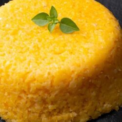 Prato de cuscuz nordestino servido com manteiga, comida de festa junina salgada.