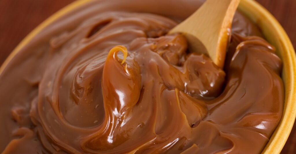 Dulce de leche argentino cremoso, servido em pote de vidro.