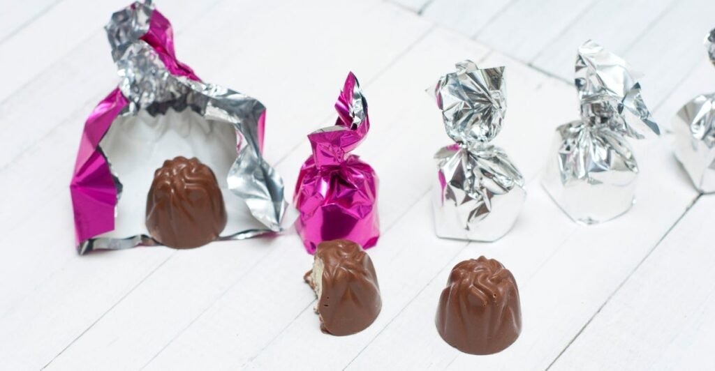 trufas de chocolate envoltas em embalagem metalizada, prontas para vender e consumir.