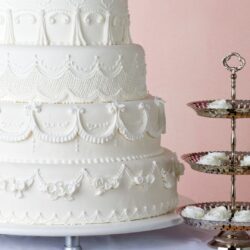 Bolo de casamento de cinco andares, decorado com glacê real detalhado em padrões elegantes.