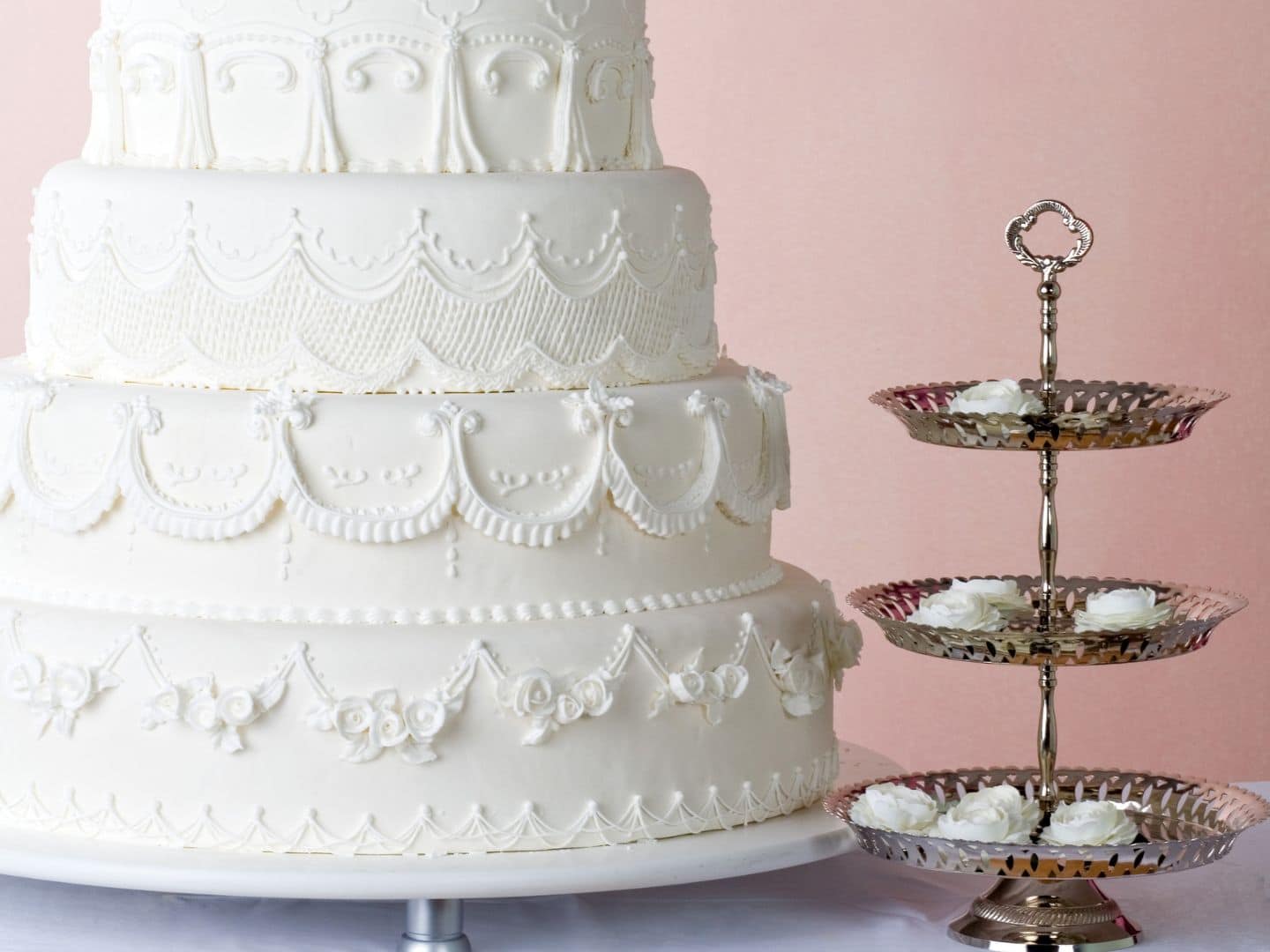 Bolo de casamento de cinco andares, decorado com glacê real detalhado em padrões elegantes.