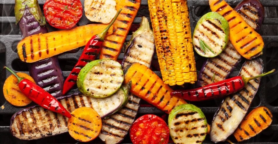 Legumes variados grelhados, como abobrinha, pimentão e berinjela, servidos em travessa com ervas frescas.