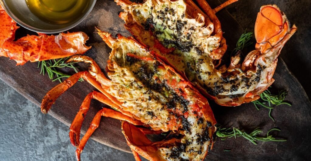 Lagosta grelhada servida com manteiga derretida e ervas aromáticas – uma das comidas com L mais sofisticadas da gastronomia.