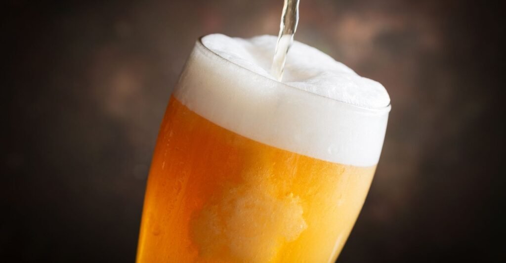 Copo de cerveja Lambic artesanal com colarinho cremoso – comidas com L e bebidas que surpreendem.