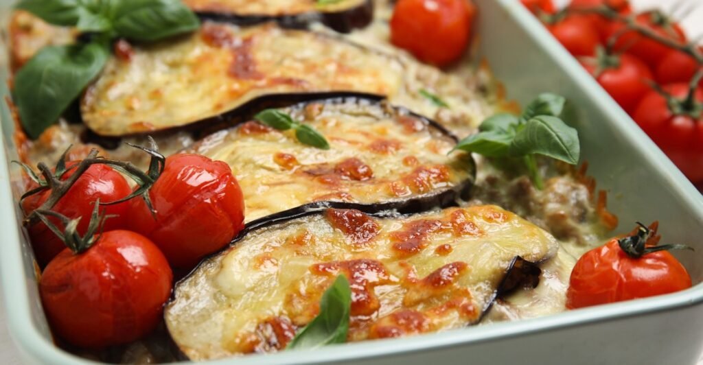 Fatia de lasanha de berinjela ou abobrinha com molho e queijo gratinado, servida em prato rústico.