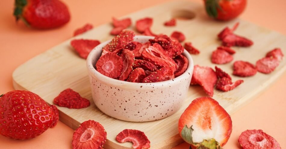 Frutas vermelhas liofilizadas em pote de vidro sobre bancada de cozinha.