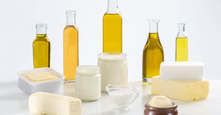 Mesa repleta de manteigas, marganina, gordura vegetal e óleos que fazem parte das bases da confeitaria e culinária