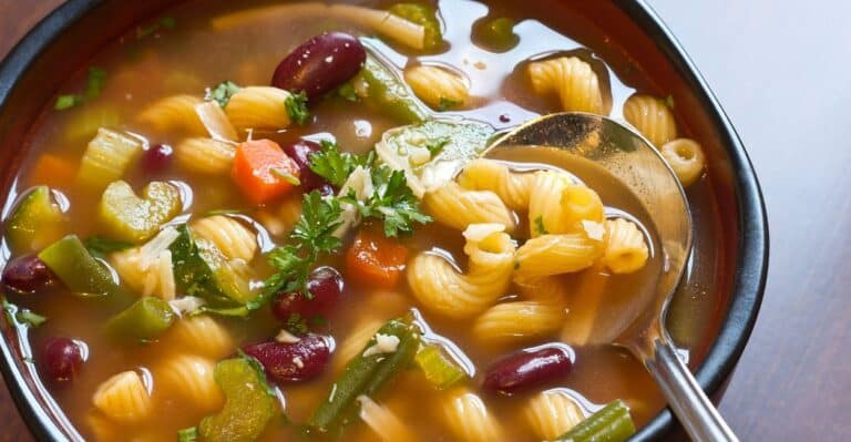 Tigela de minestrone italiano com legumes frescos, macarrão e parmesão ralado.