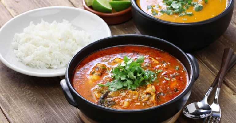 Moqueca capixaba servida em panela de barro com peixe, tomates, cebolas e coentro – comida típica do Sudeste.