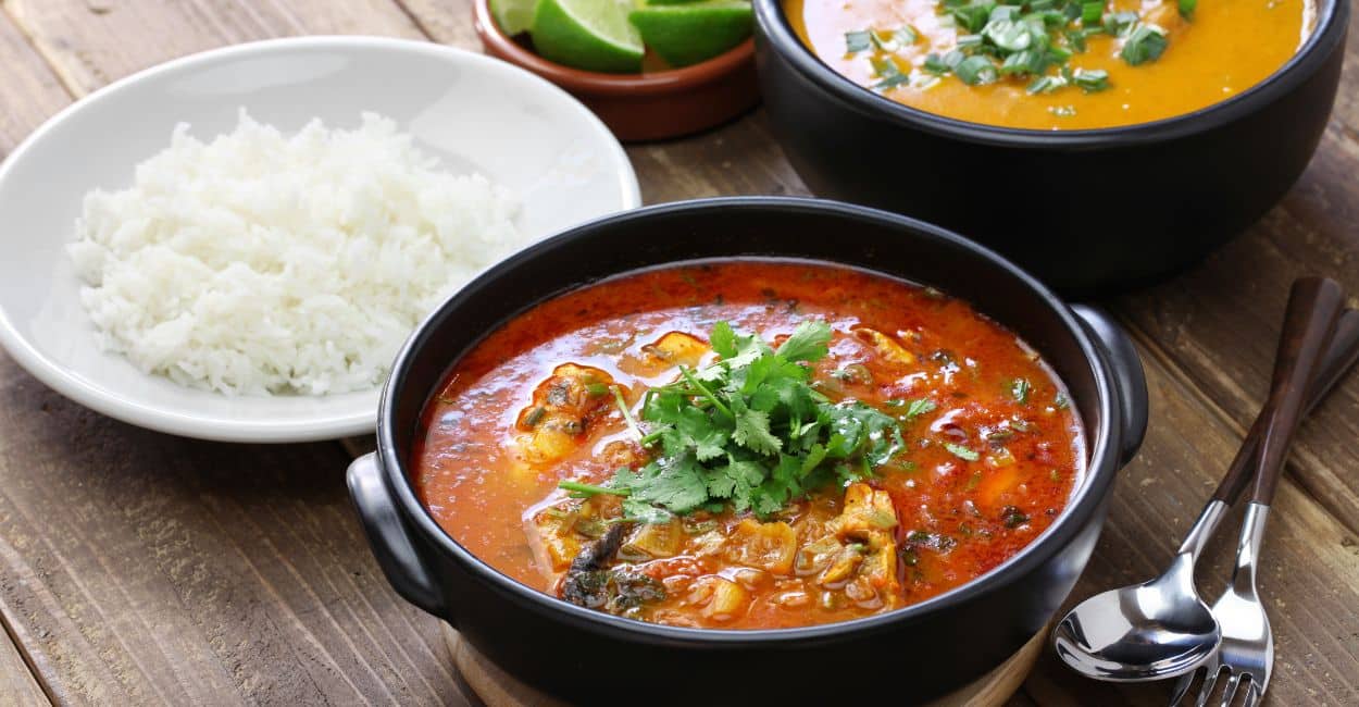 Moqueca capixaba servida em panela de barro com peixe, tomates, cebolas e coentro – comida típica do Sudeste.