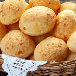 Cesta com pães de queijo dourados e crocantes – comida típica do Sudeste brasileiro.