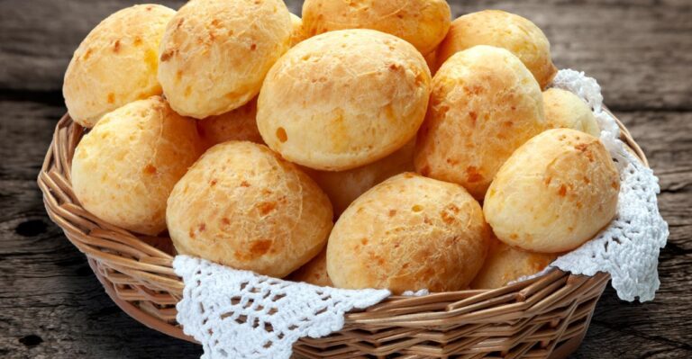 Cesta com pães de queijo dourados e crocantes – comida típica do Sudeste brasileiro.