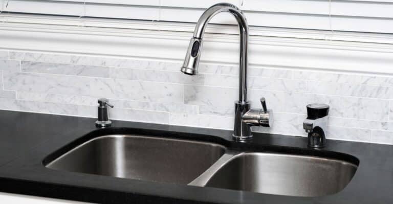 Pia de inox e granito que foi limpa com solução caseira de vinagre, bicarbonato e limão.