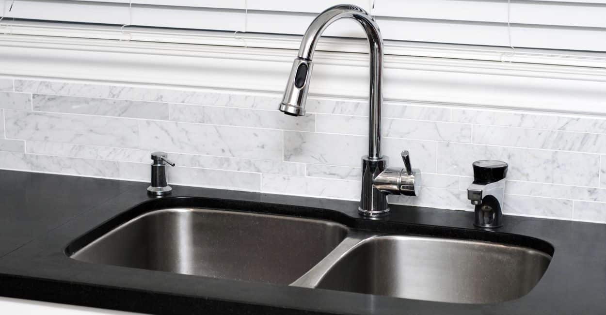 Pia de inox e granito que foi limpa com solução caseira de vinagre, bicarbonato e limão.