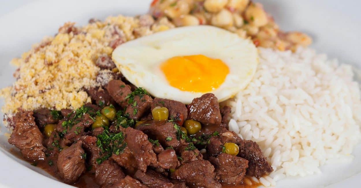 Prato de picadinho de carne com arroz, farofa e ovo – comida típica do Sudeste brasileiro.