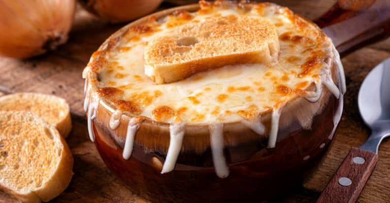 Tigela de sopa de cebola francesa gratinada com queijo derretido e pão.