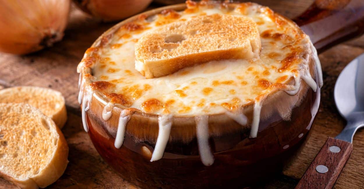 Tigela de sopa de cebola francesa gratinada com queijo derretido e pão.