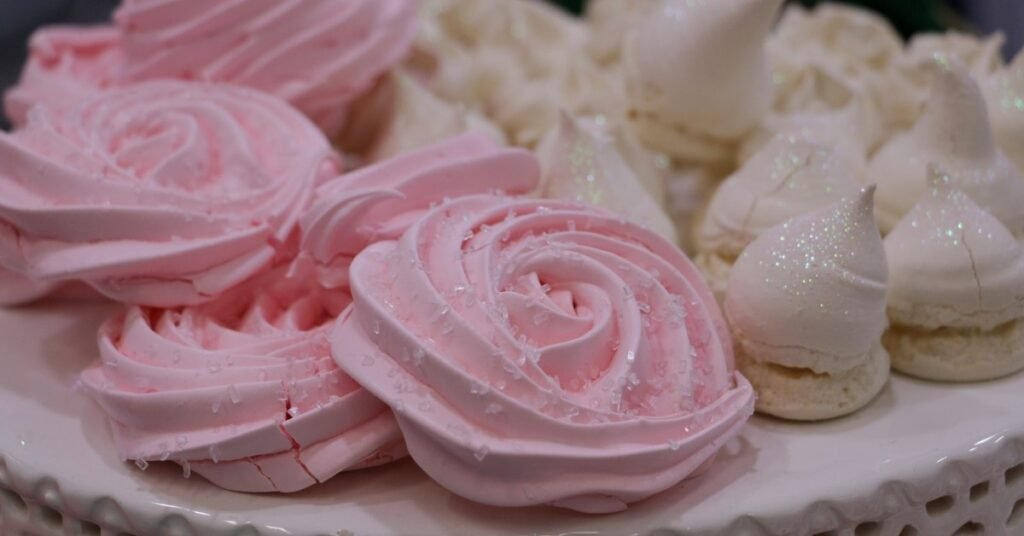 Suspiros brancos e crocantes empilhados, típicos da comida de festa junina doce.