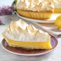 Torta recheada com creme de limão e decorada com raspas de limão.