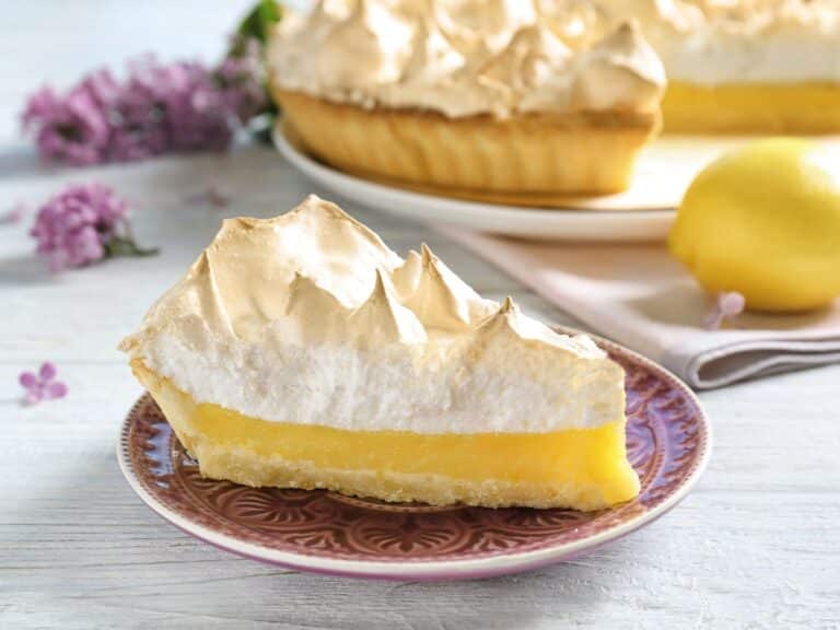 Torta recheada com creme de limão e decorada com raspas de limão.