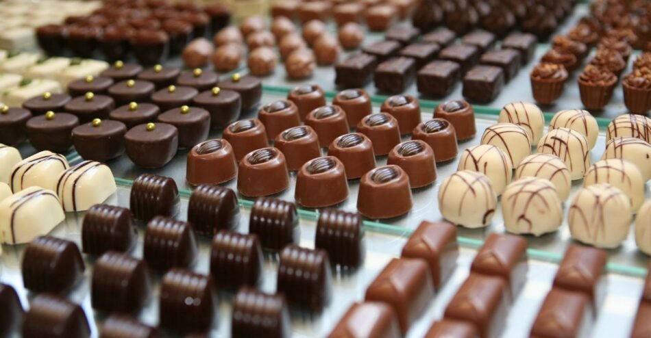Trufas de chocolate artesanais de vários sabores sobre uma mesa.