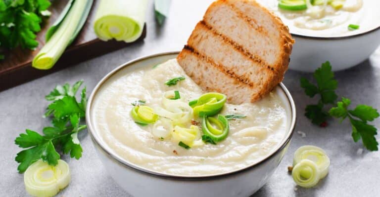 Tigela de vichyssoise francesa gelada, decorada com cebolinha picada.